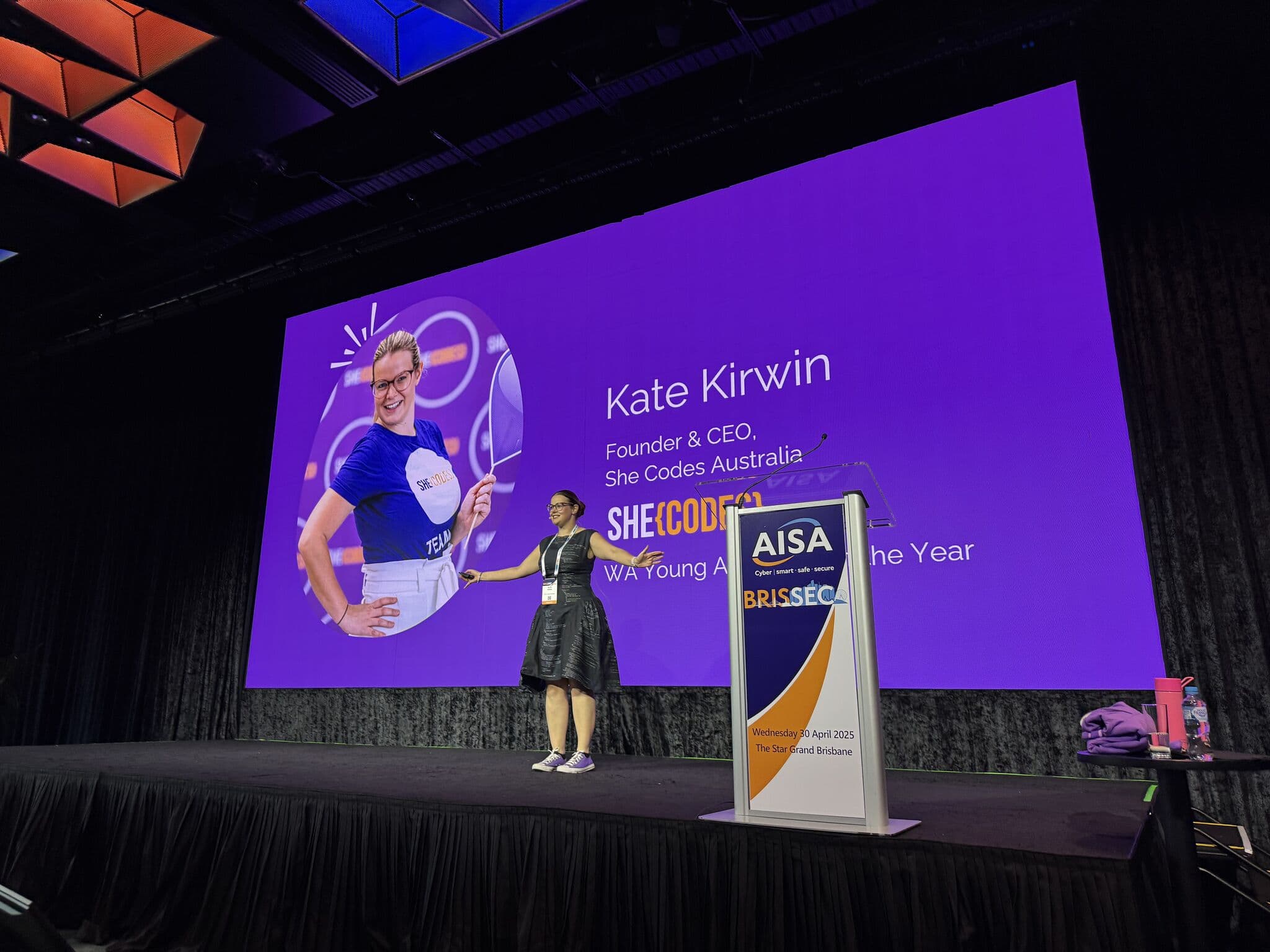 Kate Kirwin keynoting in Kate's Dress Code, her own code printed on the fabric