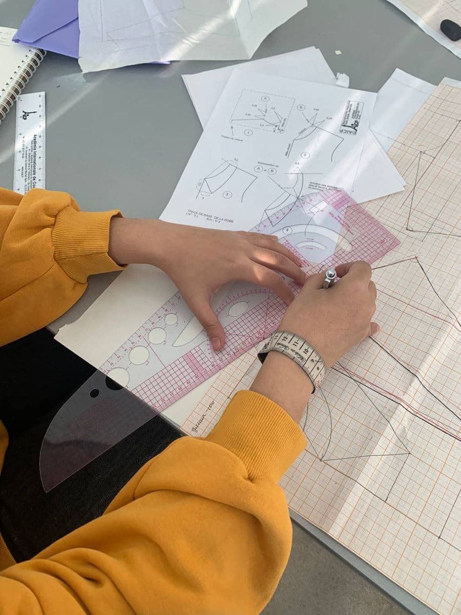 A pattern being drafted by hand on a cutting table