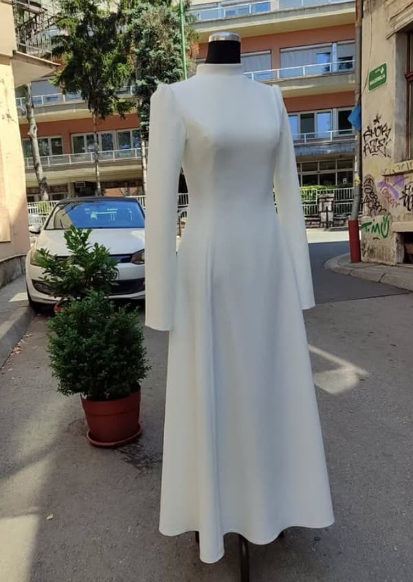 A custom ivory high-neck, long-sleeve modest maxi dress — a silhouette adapted around the wearer