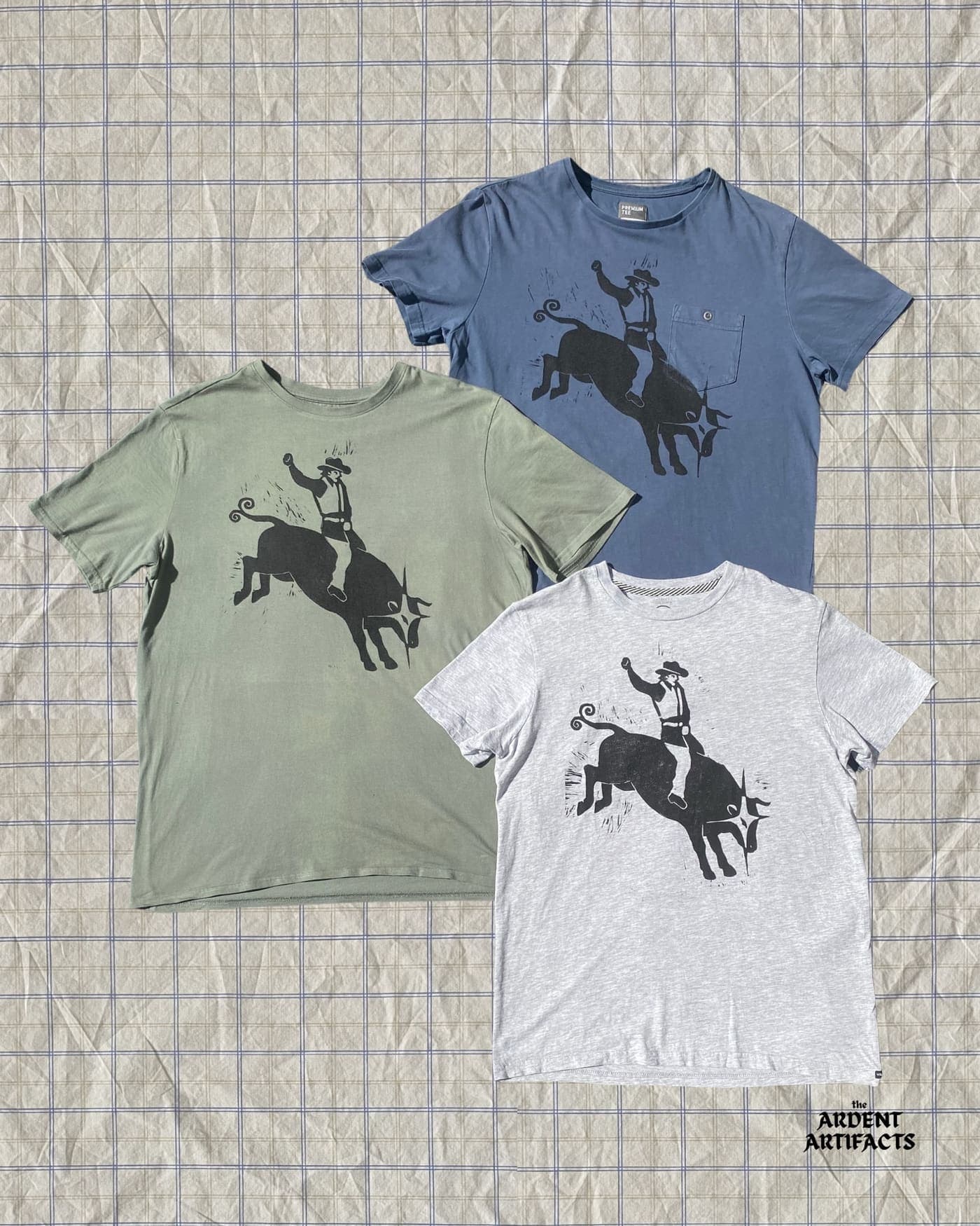 Bull rider lino print on green, blue and grey tees