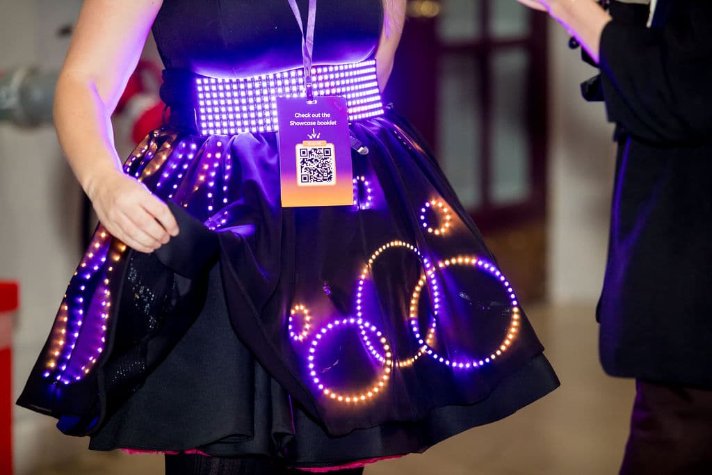 Close view of the skirt: overlapping rings of violet and amber LEDs under a sheer black overlay, a lit matrix belt above
