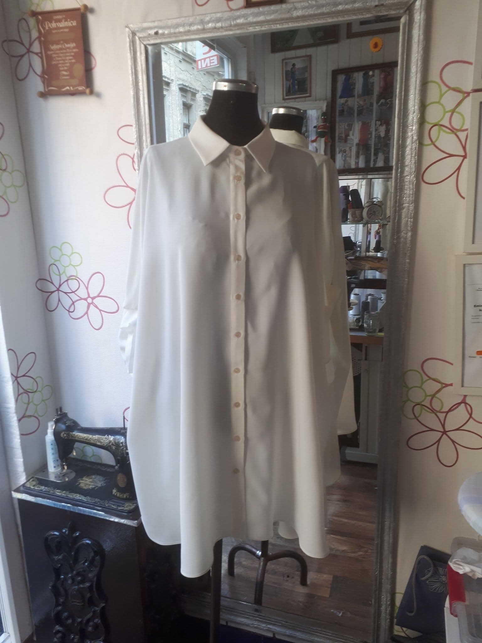 A custom white longline shirt dress taking shape on a mannequin in our tailor's studio