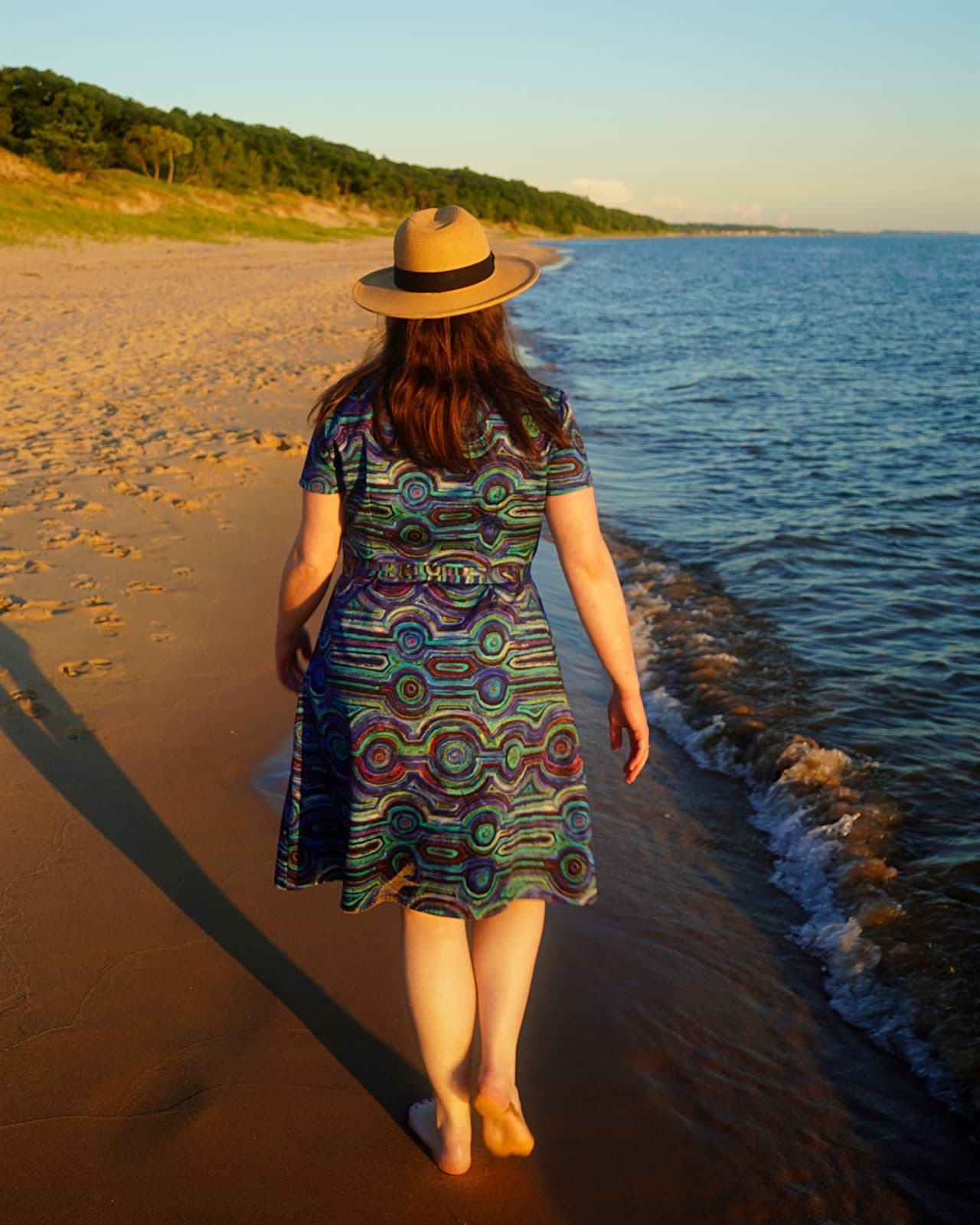 Back view of Mary's custom Emu Dreaming shirt dress by the water.