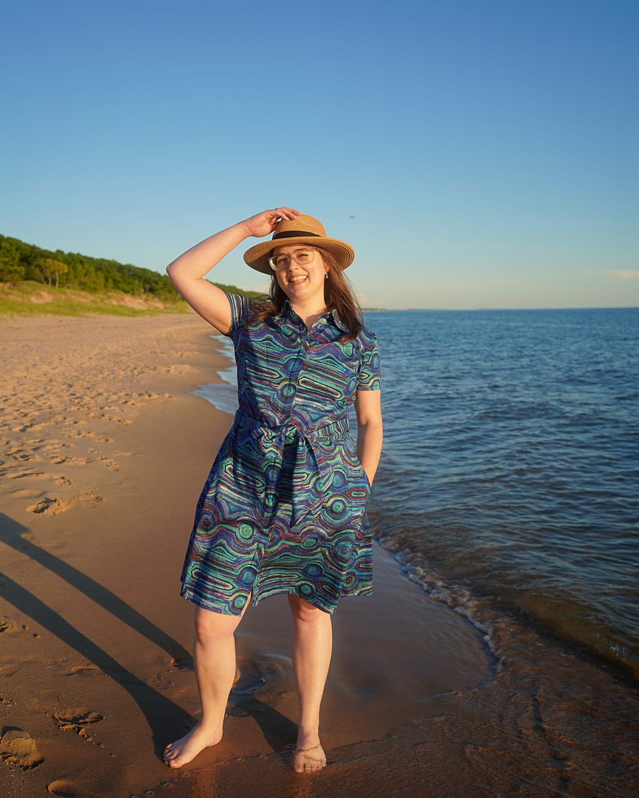 Mary wearing her custom Emu Dreaming shirt dress by the beach.