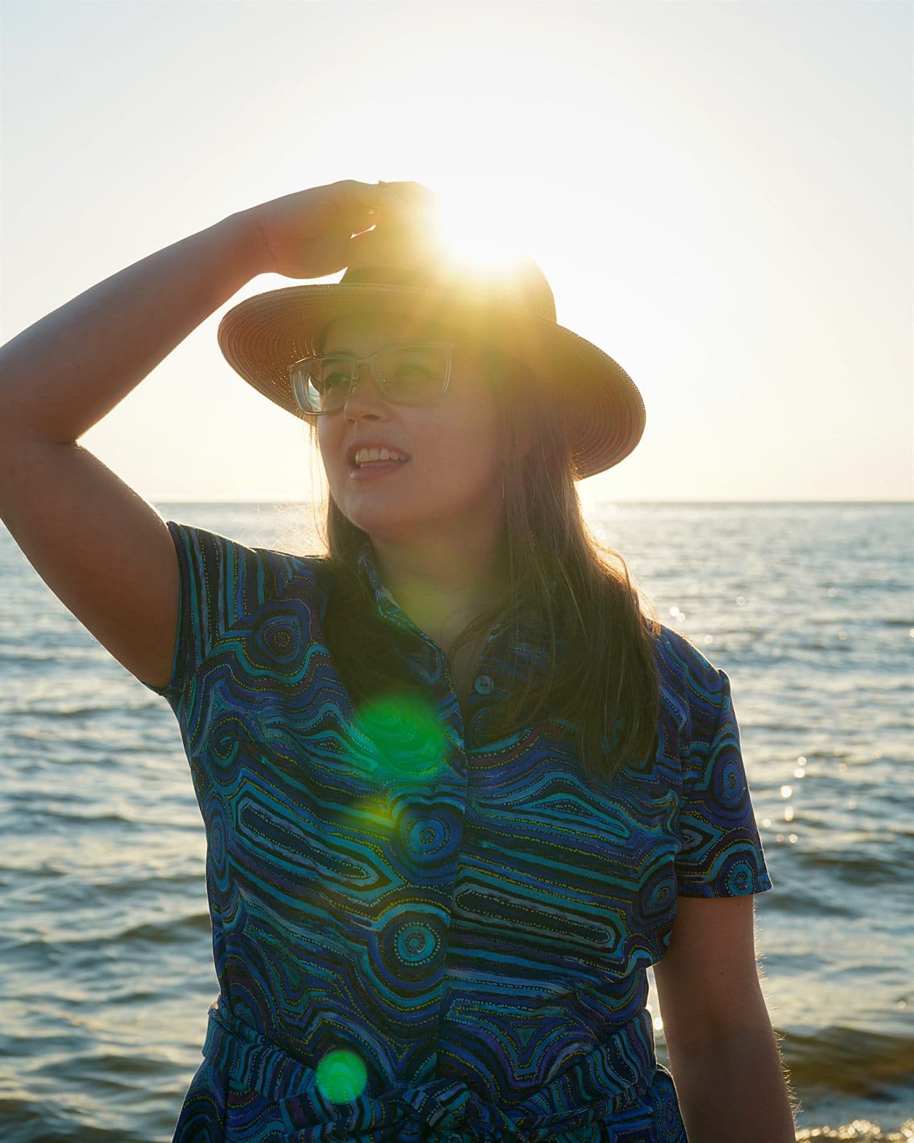 Mary in her custom Emu Dreaming shirt dress at sunset by the sea.