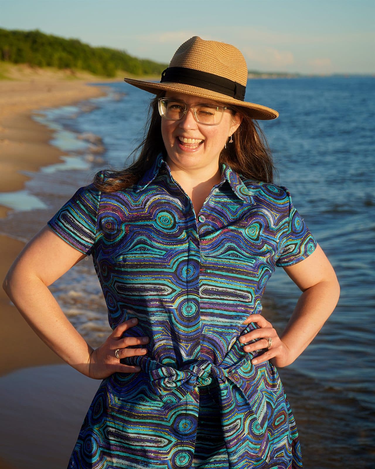 Mary wearing a blue Emu Dreaming cotton shirt dress with a waist tie on the beach.