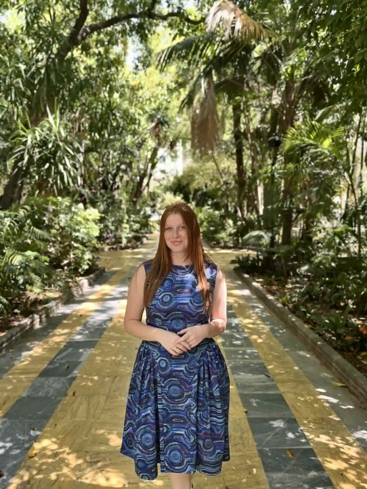 A woman wearing a custom made-to-measure dress in a blue First Nations print