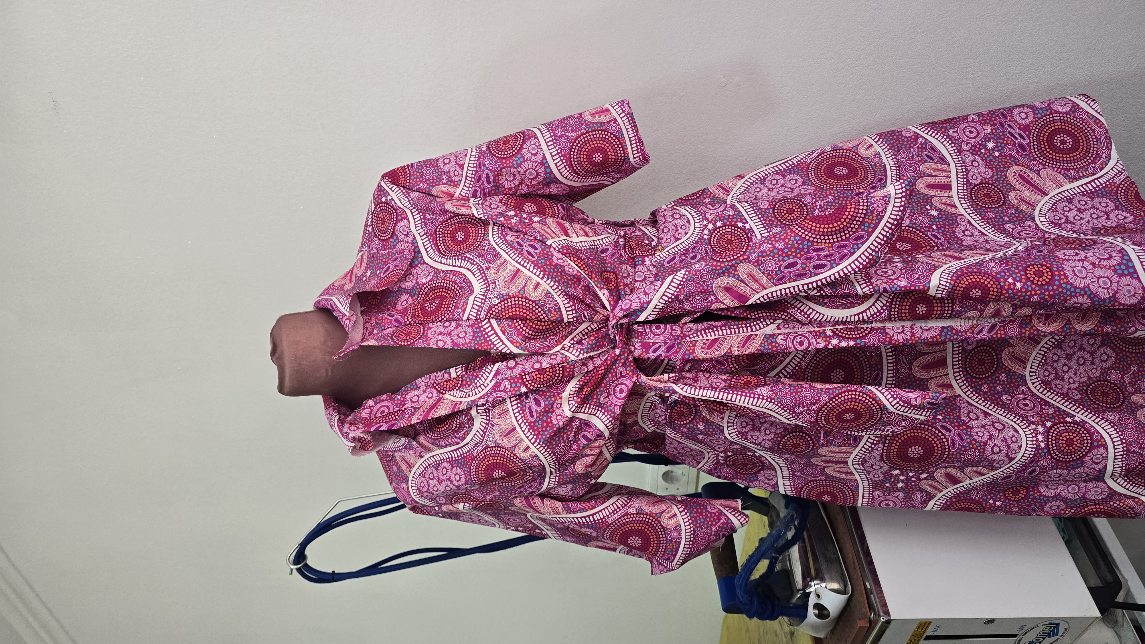 A First Nations print dress pinned on a mannequin during construction